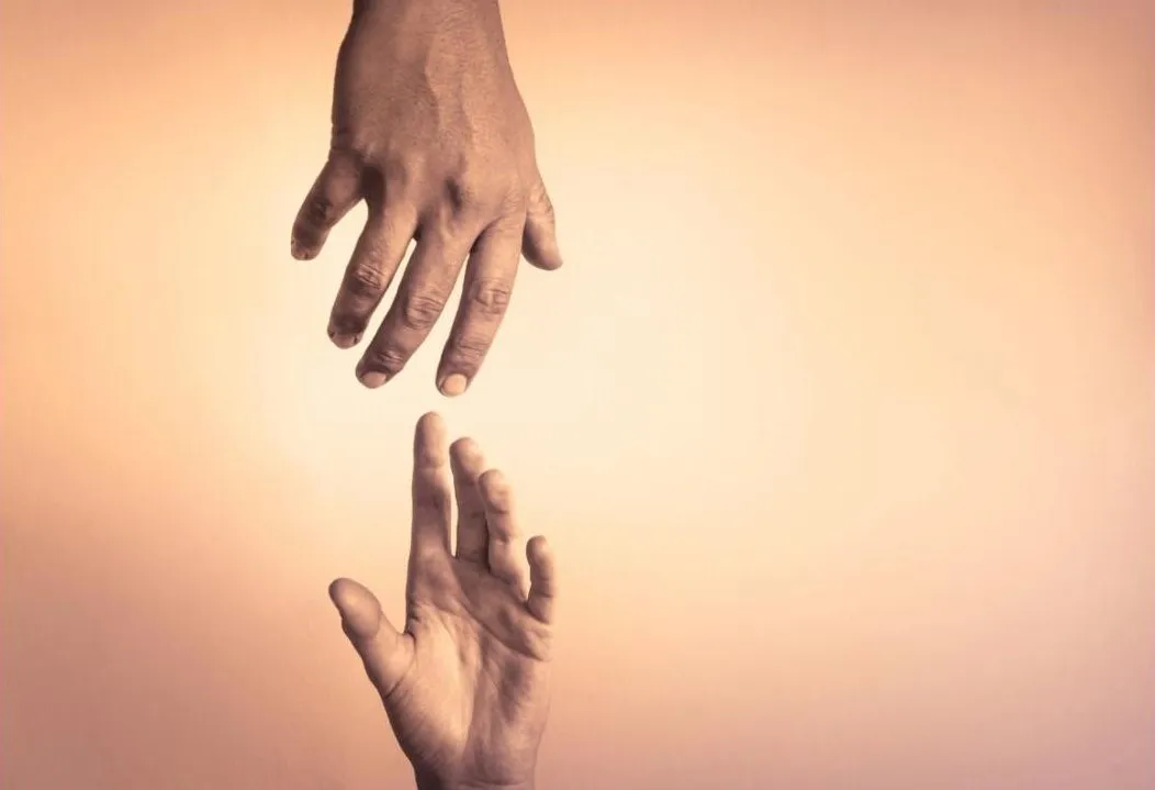 Two hands reaching toward each other